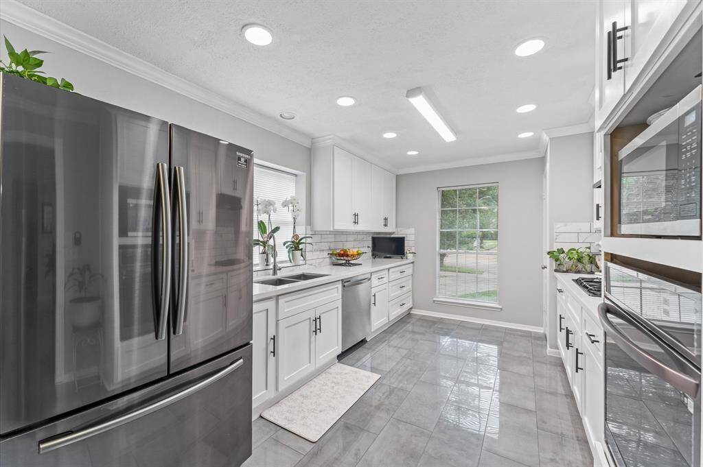 Immaculate completely reimagined kitchen with quartz countertops and stainless steel appliances.