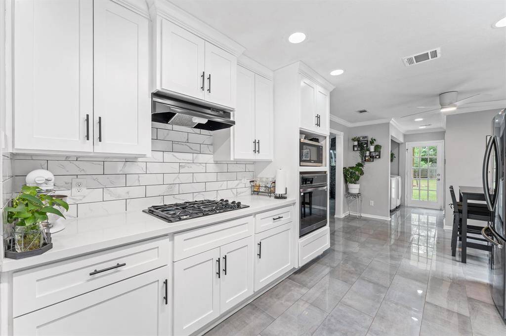 Immaculate completely reimagined kitchen with quartz countertops and stainless steel appliances.