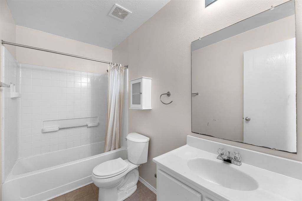 The guest bath has a shower tub combo and tile flooring