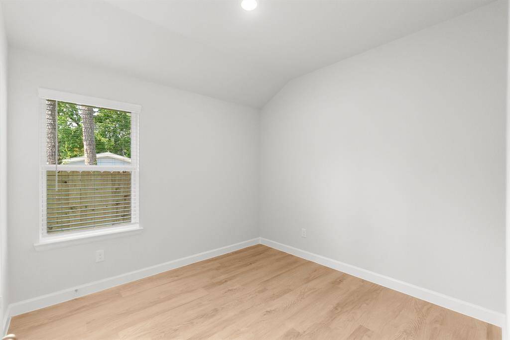 Bright and inviting room with light wood flooring and ample natural light, ideal for an office or bedroom.