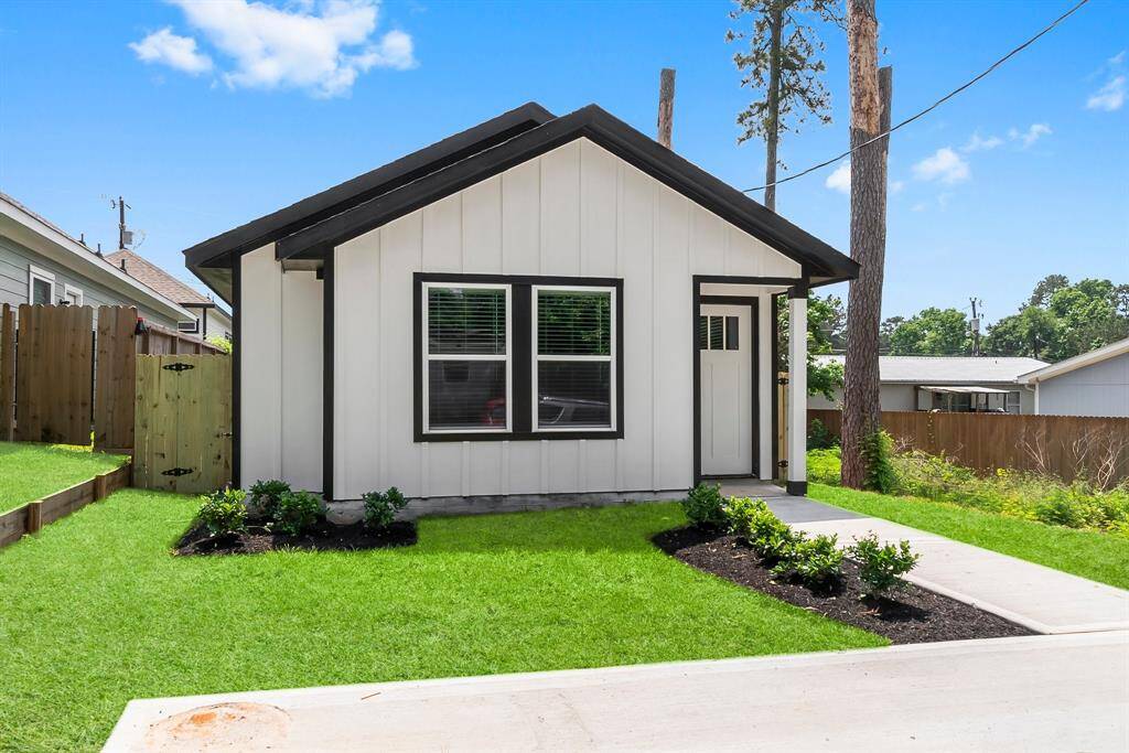 Modern home with a sleek black-and-white exterior and a beautifully landscaped yard. Ideal for minimalist living.