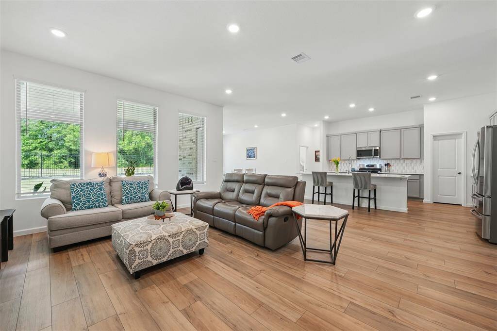 The spacious living room, adjacent to the kitchen, offers a cozy space with serene forest views, perfect for relaxing or entertaining.