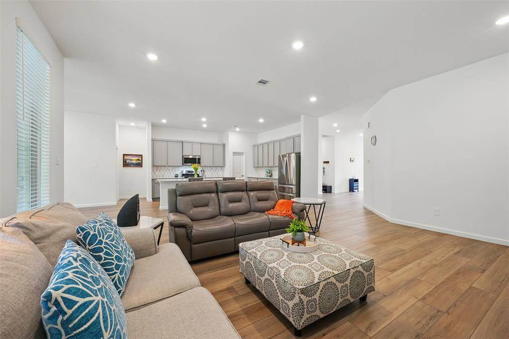 The spacious living room, adjacent to the kitchen, offers a cozy space with serene forest views, perfect for relaxing or entertaining.