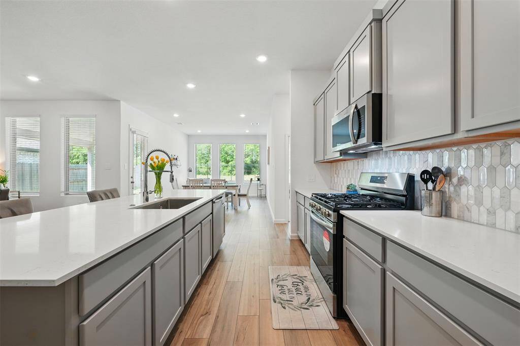 The kitchen features a large island, plenty of storage space, and sleek quartz countertops, making it both functional and stylish.
