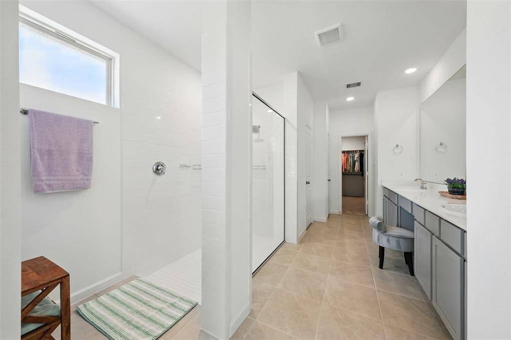 The primary Bathroom:Offers comfort and functionality with dual sinks, a walk-in shower, a separate toilet area, and an extra closet for additional storage.