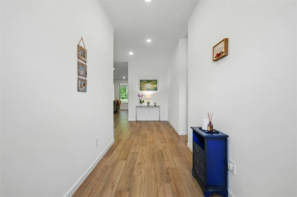 As you step inside, a spacious hallway and a thoughtfully designed entryway welcome you with warmth and functionality, creating an inviting first impression and a comfortable space to settle in.