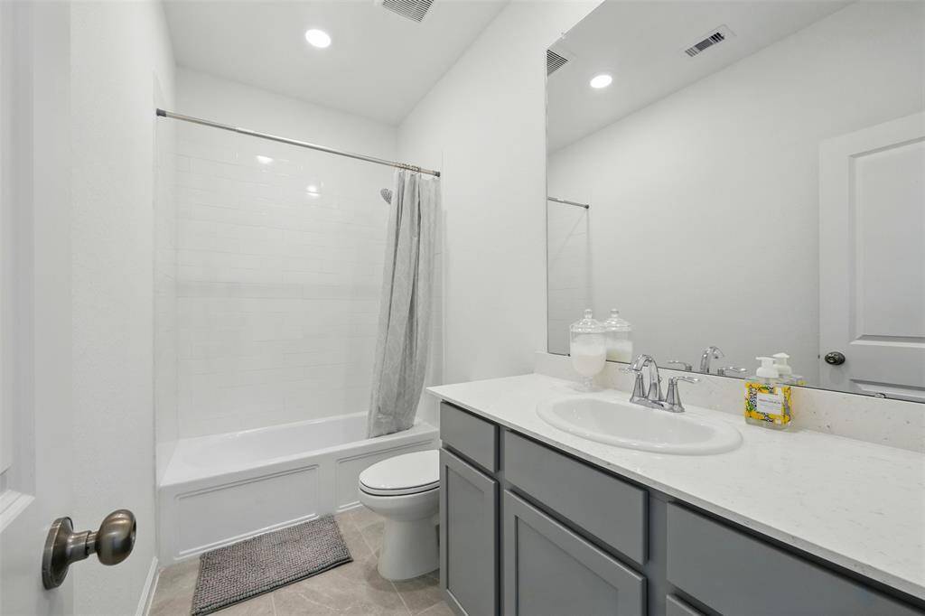 A full bathroom near the entryway serves both as a convenient powder room for guests and provides added functionality for the adjacent guest or in-law room.