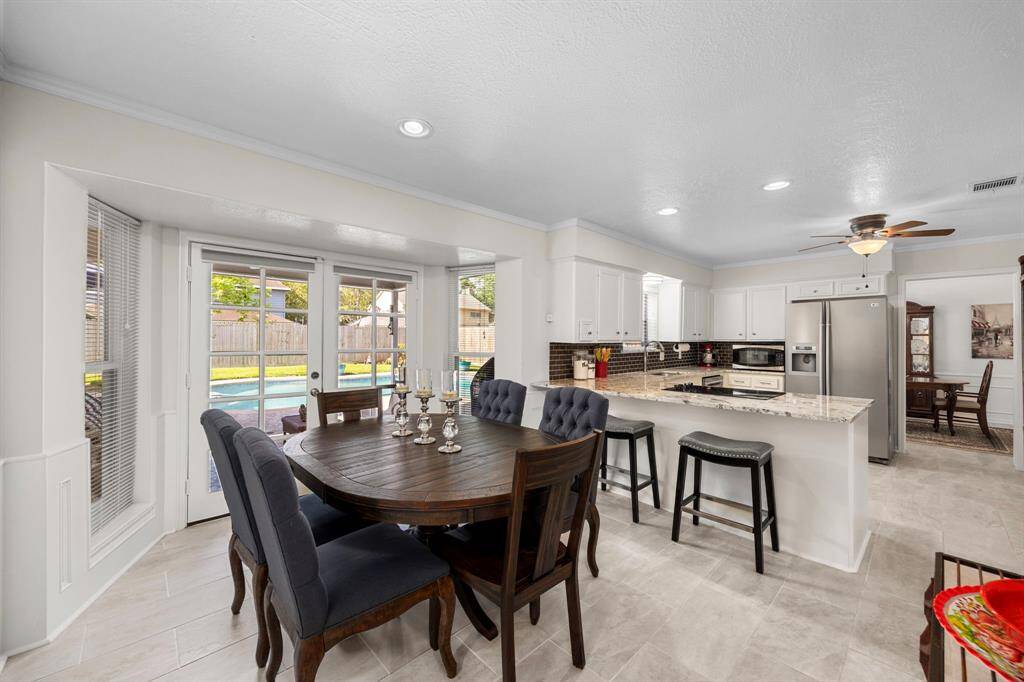 Attractive breakfast area overlooks pool and has door to outside living area.