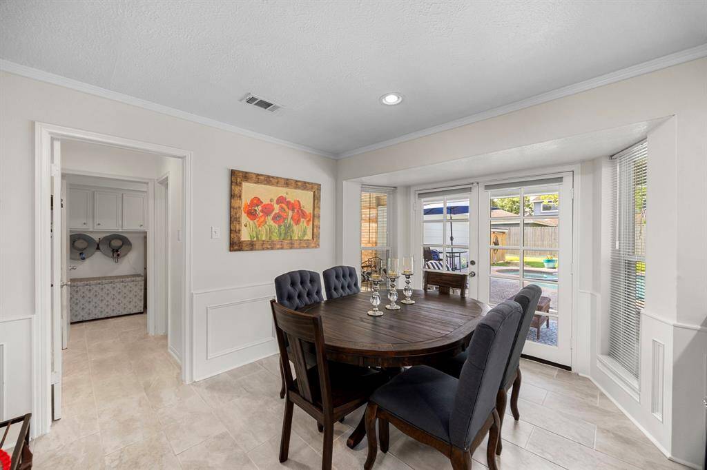 To the left of breakfast area is powder bath, laundry room and door to covered area to garage
