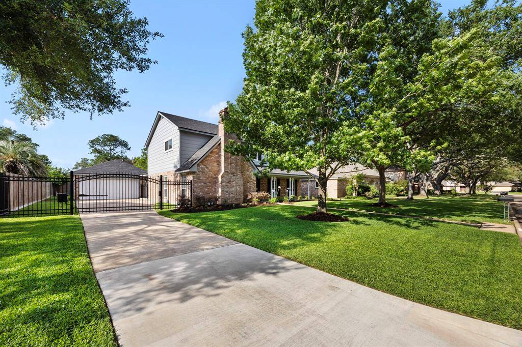 Home features an automatic driveway gate and 2 beautiful mature trees in front yard.