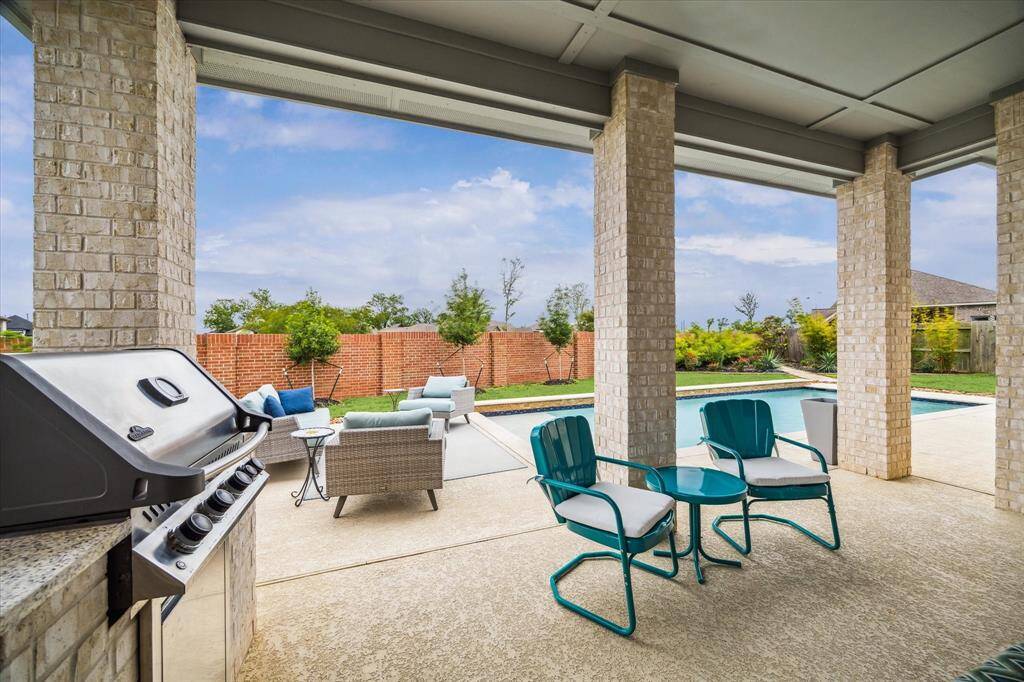 Fire up the grill and unwind in style beneath the spacious covered patio, featuring a built-in summer kitchen with a stainless steel grill, sink, and ample counter space. With room to dine, lounge, and enjoy the poolside views, this space is made for year-round outdoor living and effortless entertaining.