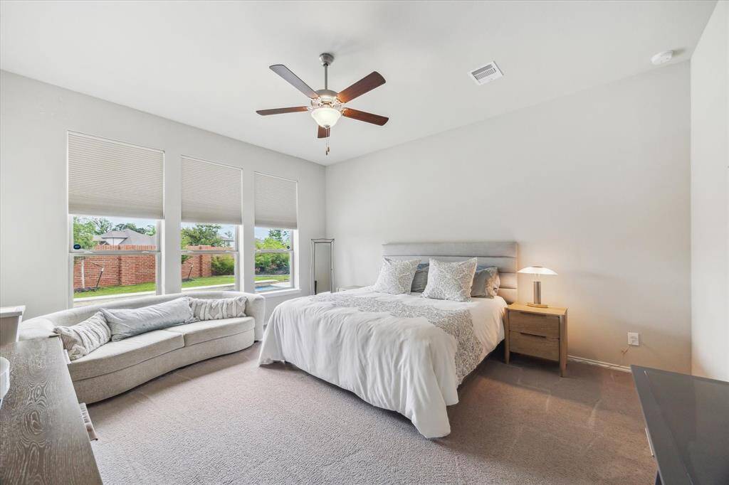 You’ll have sweet dreams in this posh owner’s retreat featuring plush carpet, neutral paint, a wall of windows, a cooling fan, a large walk-in closet, and a luxurious ensuite bath.