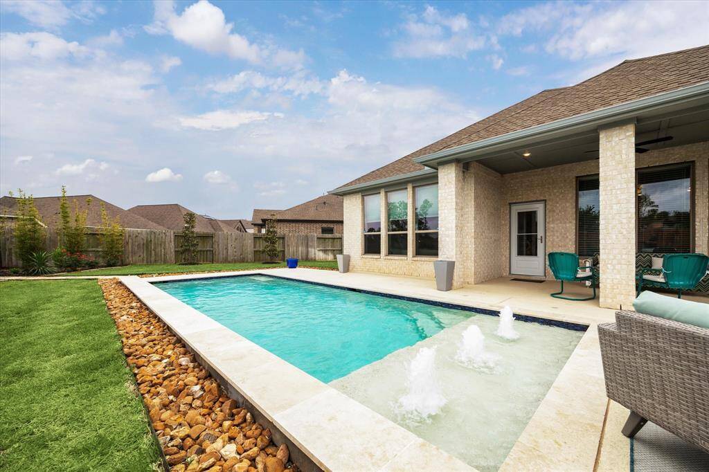Enjoy the best of outdoor living with a sparkling pool with tanning ledges and bubbling water features, all just steps from your covered patio with a fully equipped summer kitchen. Whether you're lounging poolside or hosting a weekend get together, this backyard is designed for year-round enjoyment.