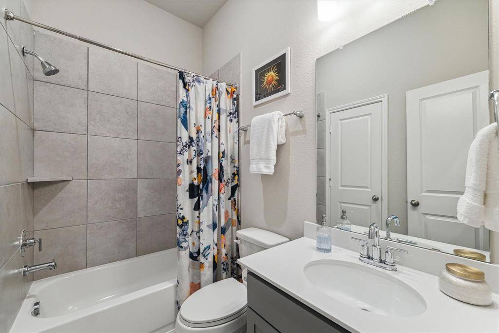 With three full bathrooms, the morning rush will be a breeze. This guest bath features a single-sink vanity with a full mirror and vanity light above, along with a fully tiled tub/shower enclosure.