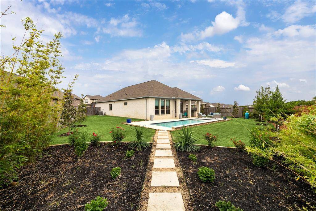 Looking back from the garden, you’ll take in a view that has it all, Holly and Magnolia trees, vibrant landscaping, expansive grassy space with a full sprinkler system, a sparkling pool with sun deck, and a covered patio complete with a summer kitchen. This backyard delivers everything you need for the ultimate stay-cation.