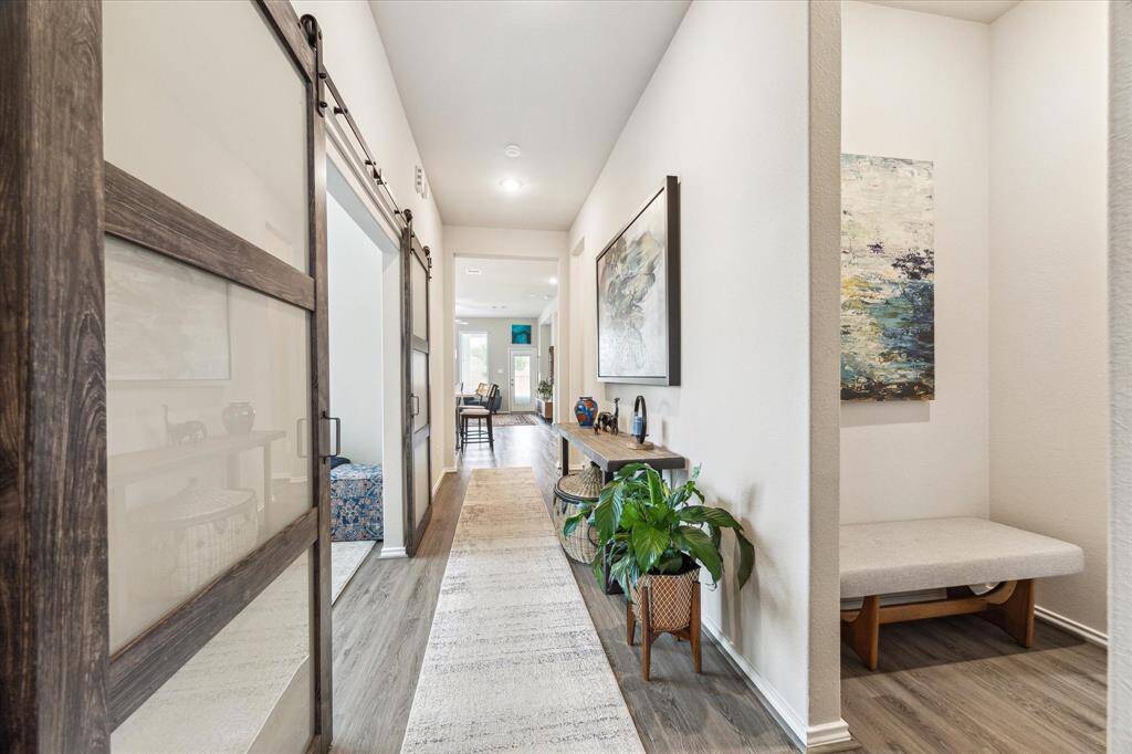 Modern glass sliding doors make a bold statement and open to a flexible space that’s perfect for a home office, game room or alternate living space. A stylish detail that blends form and function within the home’s thoughtful design.