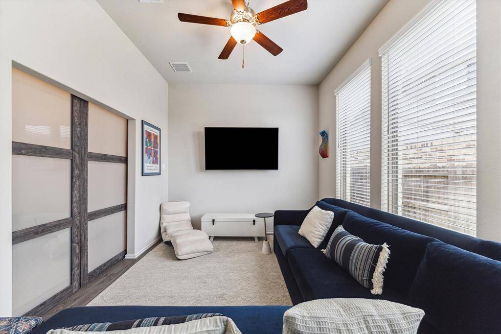 Light-filled and full of potential, this flexible space has everything you need, chic sliding doors, big windows, neutral tones, and LVP flooring. Use it as a game room, home office, alternate living area, or whatever fits your lifestyle.