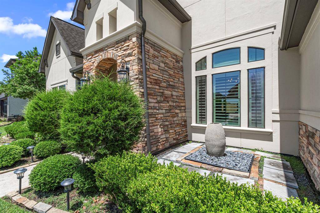 Well maintained landscaping and water feature in front of the home