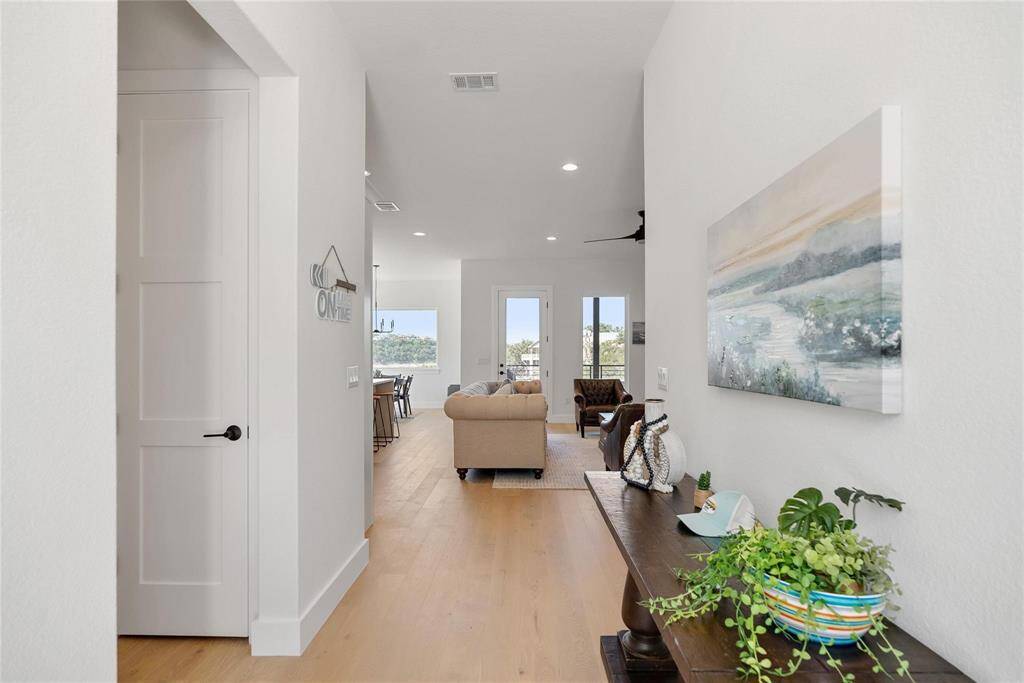 This entry way leads to a bright, open living area with light wood flooring, providing a naturally bright and neutral canvas for any kind of decor.