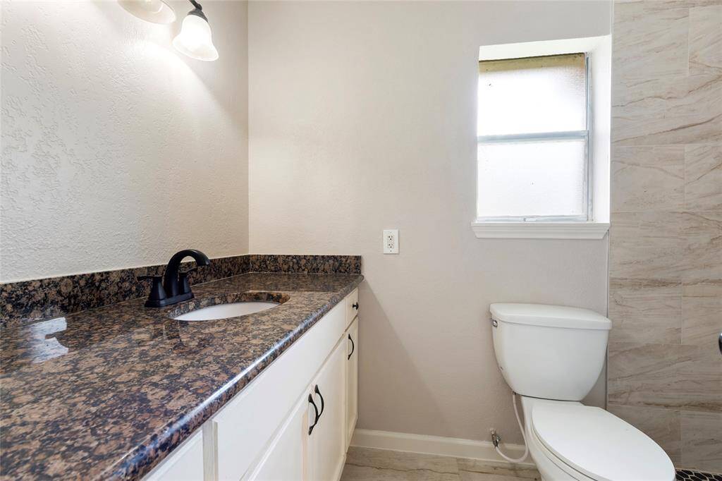 Primary bathroom has been renovated with a new walk-in shower, sink and toilet.
