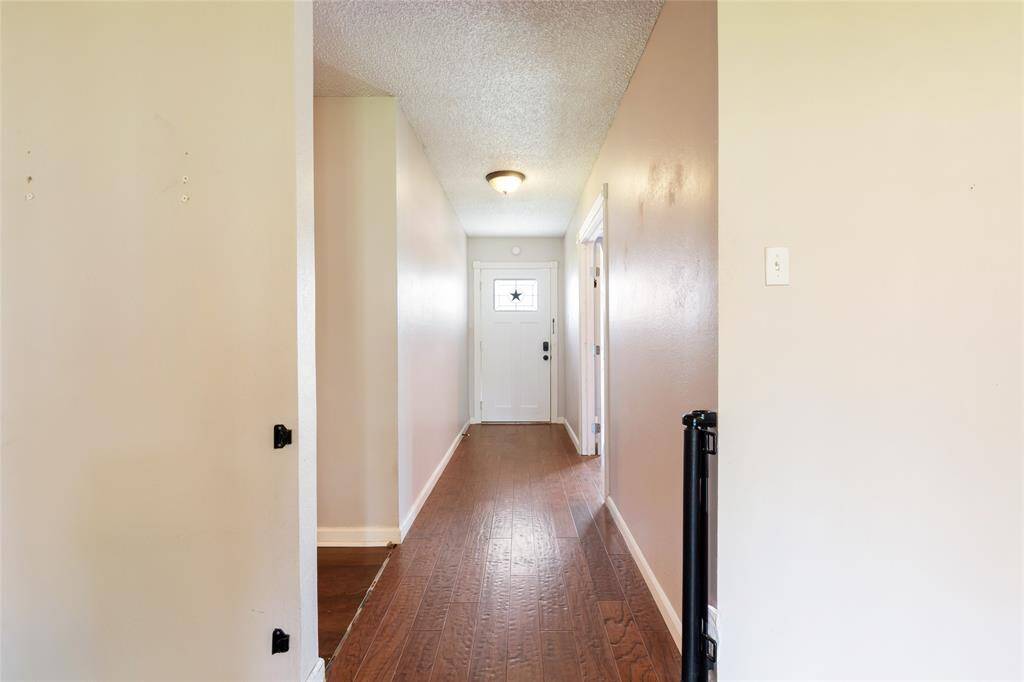 Looking towards the front door from the living area. Rooms are located to the left.