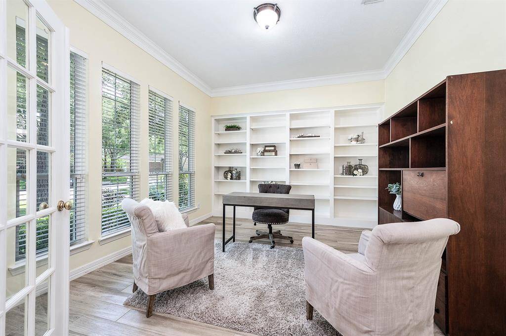 Bright home office featuring built-in bookcases and expansive windows.