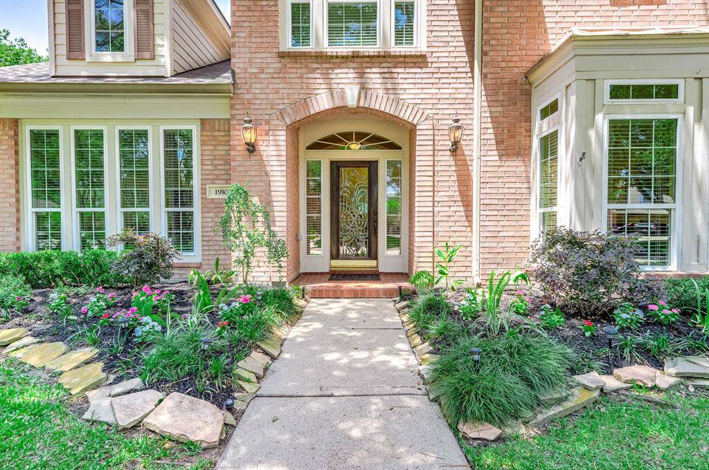 This charming home features large windows and a beautifully landscaped front yard.