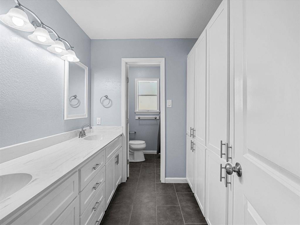 Hall bathroom features dual sinks with separate vanities and ample storage space