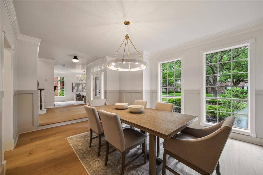 MODERN LIGHTING INSTALLED IN THE DINING ROOM ENHANCES THE BOARD AND BATTEN MOLDING AND NEUTRAL PALETTE.