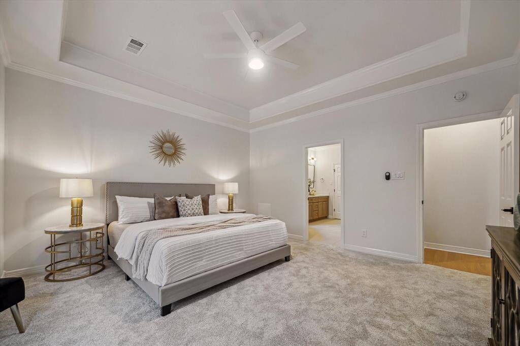 THE PRIMARY BEDROOM EASILY SUITS A KING SIZE BED AND FEATURES A TRAY CEILING AND PLUSH CARPETING (NEW 2025).