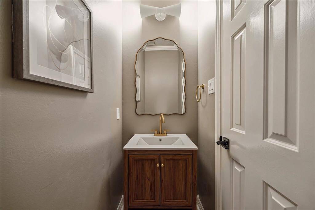 GUESTS WILL ENJOY THE UPDATED POWDER BATHROOM WITH UPGRADED TOILET, VANITY, SINK, FAUCET, LIGHTING, AND MIRROR.