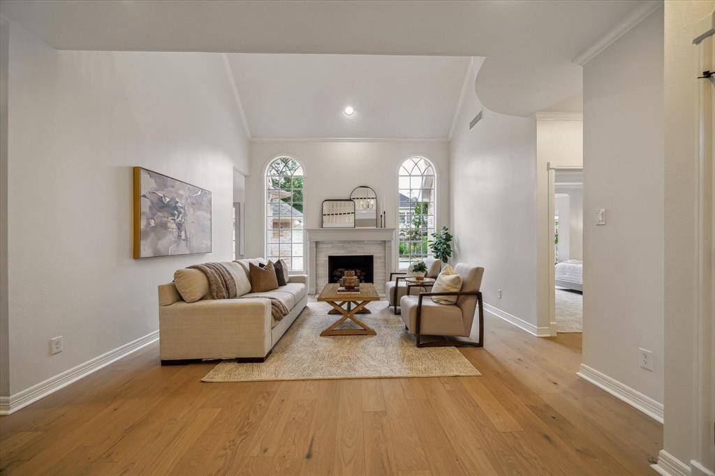 THE GRAND FAMILY ROOM BOASTS UPDATED FLOORING, UPDATED FIREPLACE SURROUND, PLUS CROWN MOLDING AND SOARING CEILINGS.