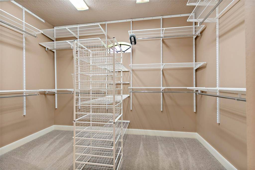 Expansive walk-in closet outfitted with custom shelving and drawer organizers to maximize storage and functionality.