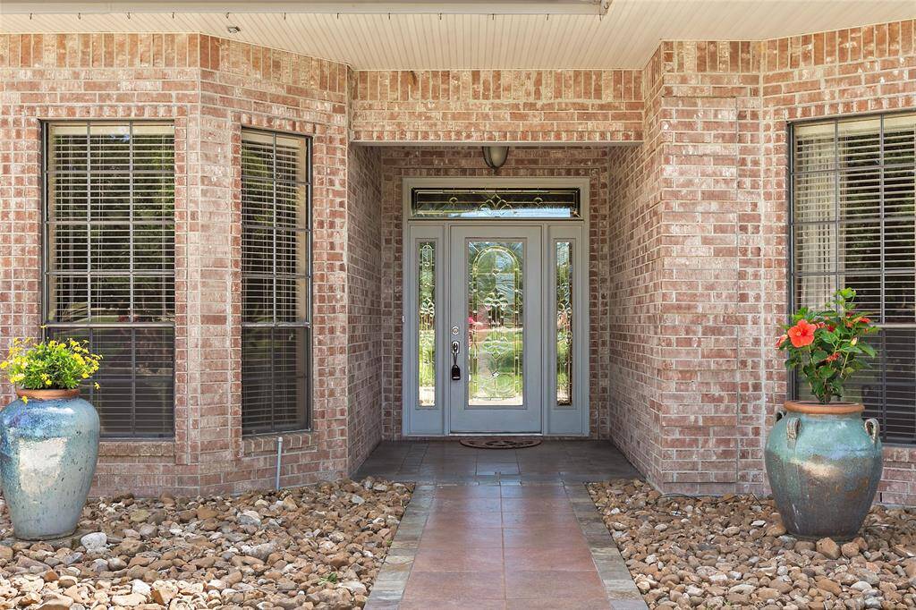 Classic brick front elevation featuring elegant front doors, covered entryway, and timeless curb appeal.