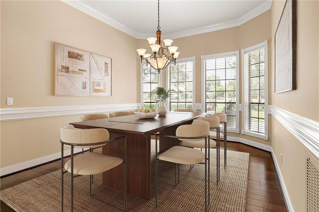 Formal dining room with crown molding, chandelier lighting, and large windows that allow natural light to pour in.