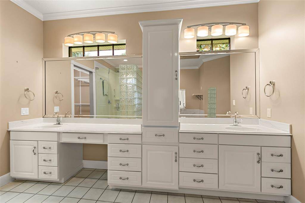 Ensuite bathroom featuring dual vanities with ample storage.