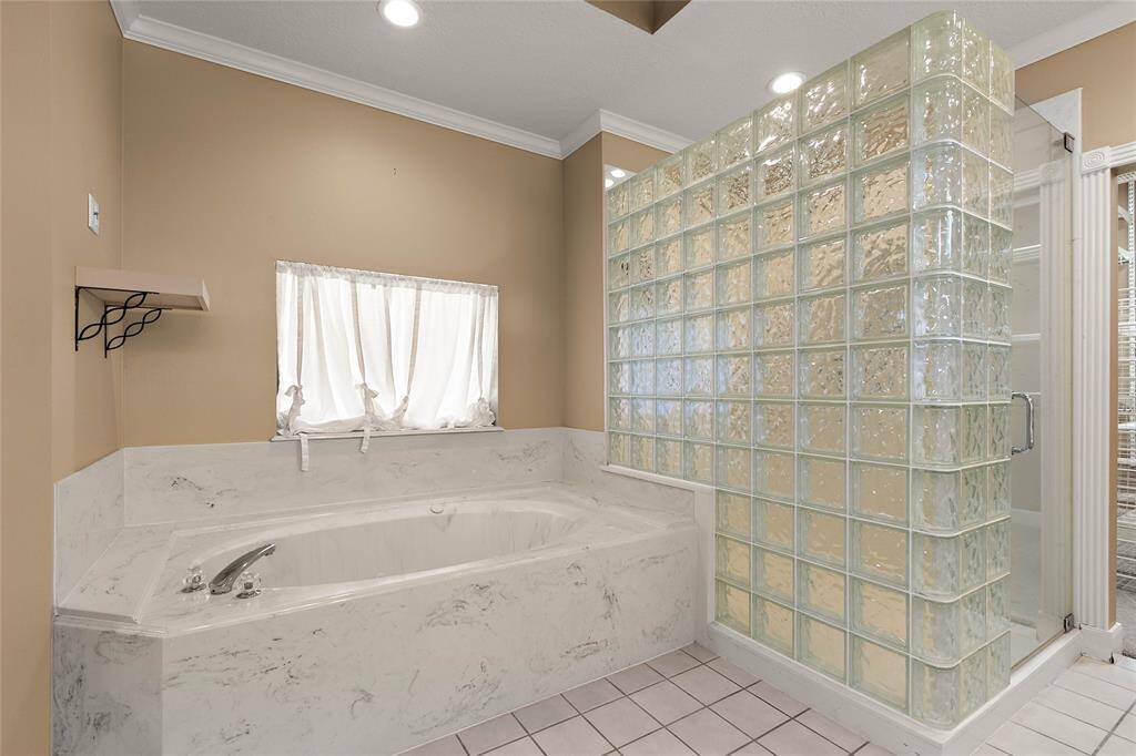 Primary ensuite bath with relaxing soaking tub, and separate glass-enclosed shower.