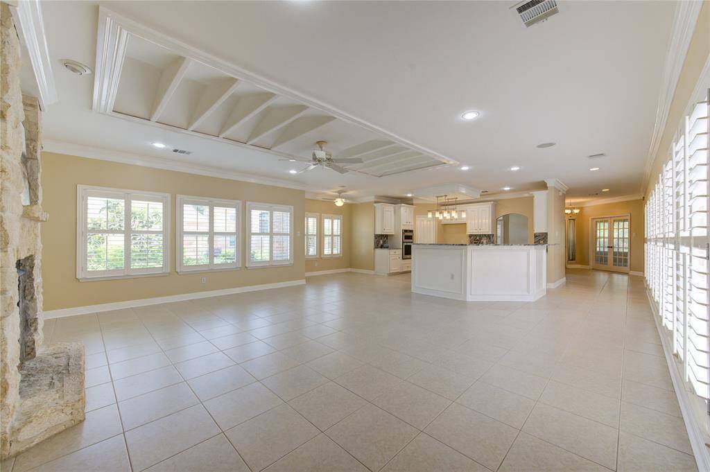A stunning wall of windows framed by classic plantation shutters, allowing natural light to flood the room while maintaining privacy and style.