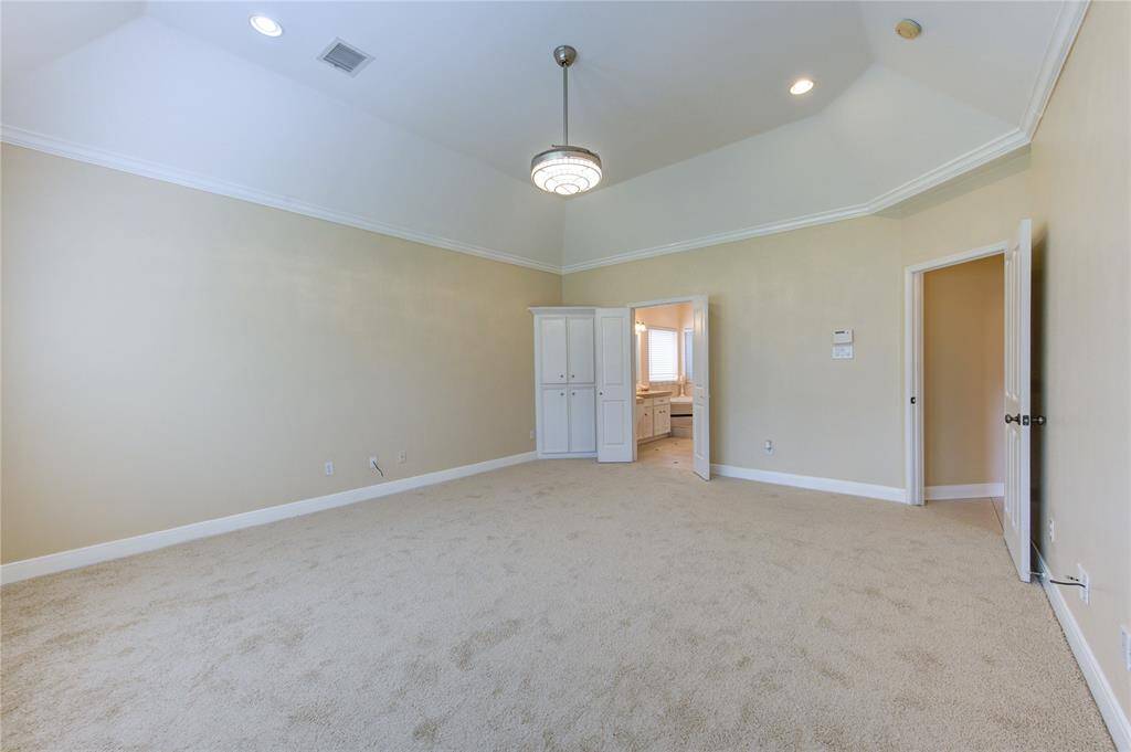 Elegant primary bedroom with tray ceilings, adding depth and sophistication to the space.