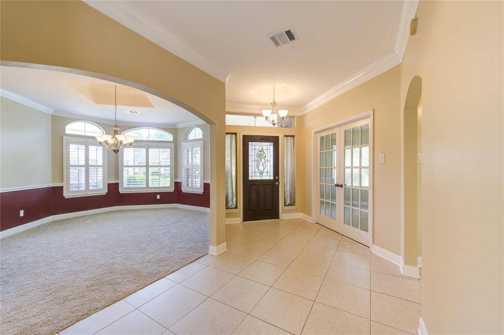 Inviting entry with views of the home office and formal dining room, both filled with natural light and elegant finishes.
