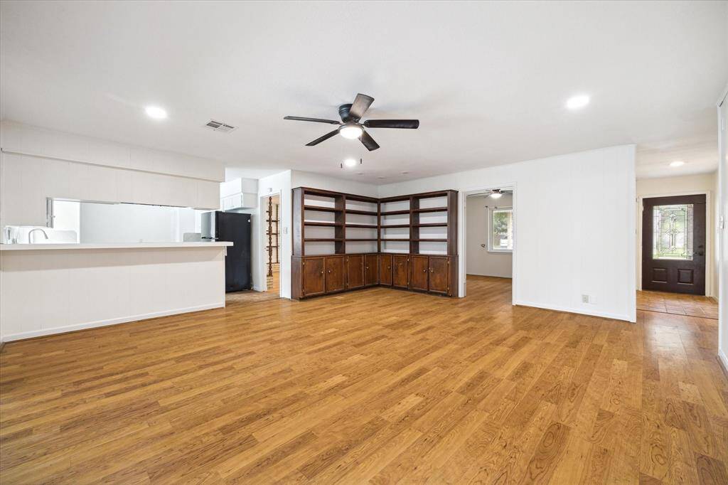 Living room with built-ins and breakfast bar in kitchen.