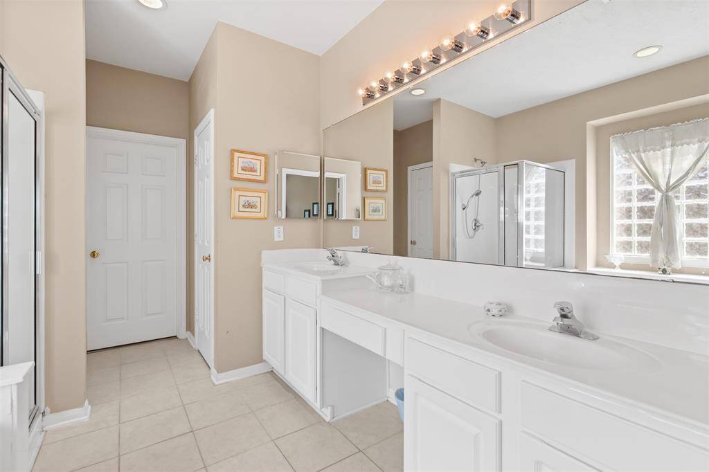 Primary bathroom features double sinks with knee space vanity area.