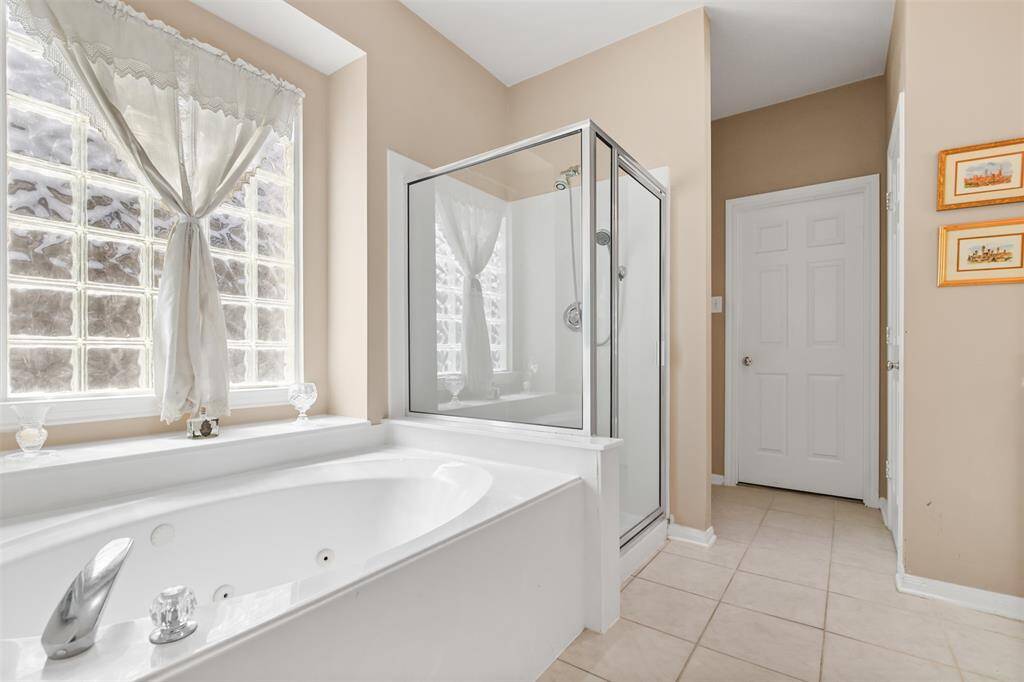 The primary bathroom has a garden tub and separate glass door walk in shower.