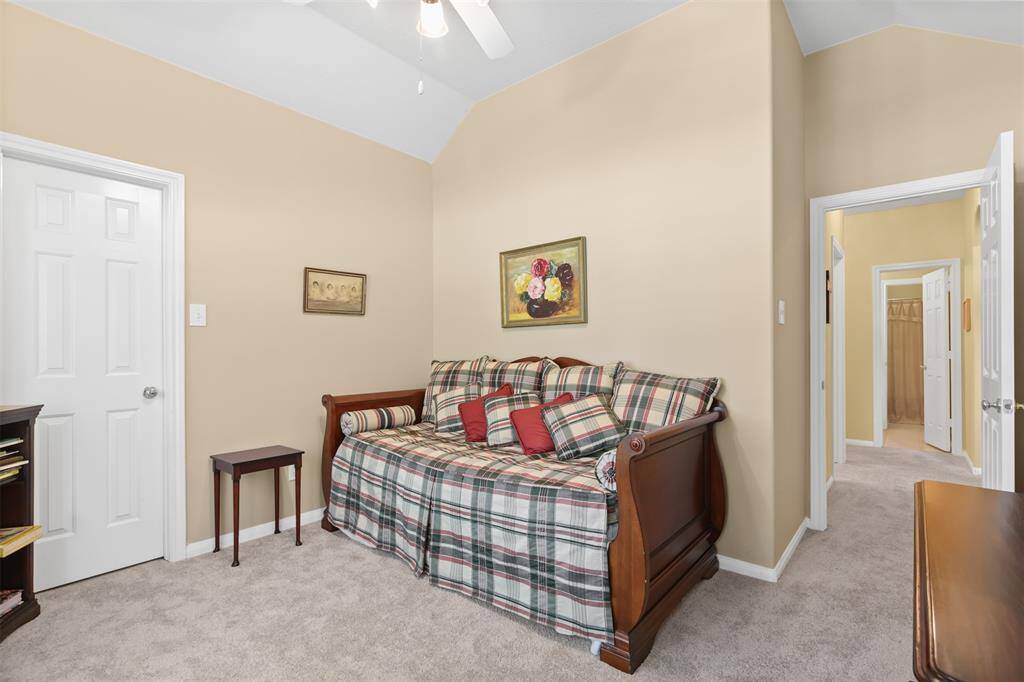 Secondary bedroom has carpet and ceiling fan.