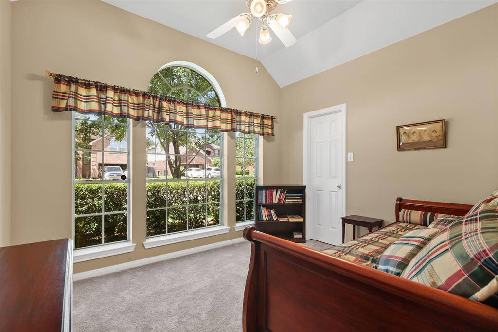 Another view of the secondary bedroom with large windows looking onto the front yard.