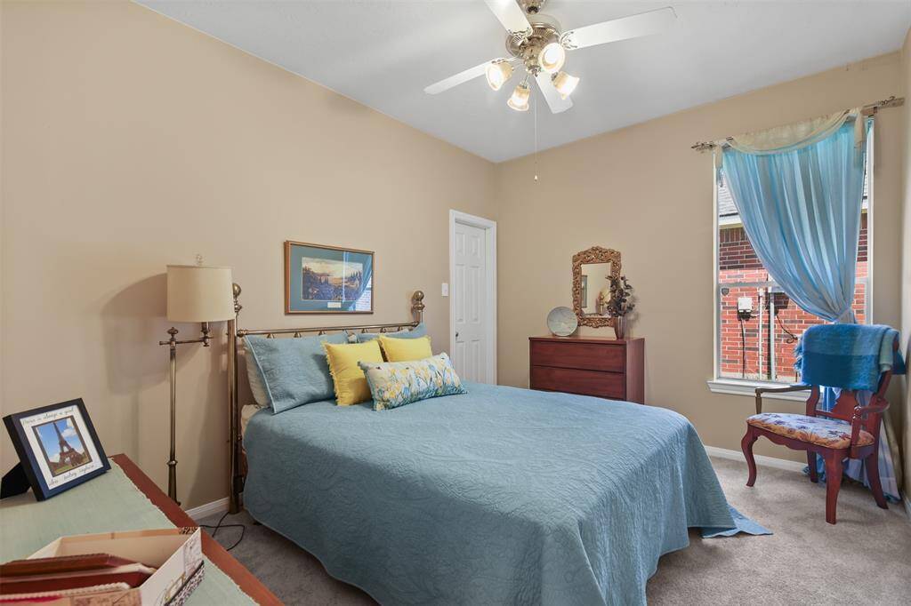 Additional secondary bedroom with carpet, ceiling fan and picture window.