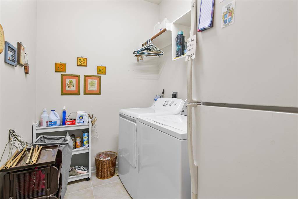 Utility room in house has shelves and hanging space as well as space for a refrigerator.