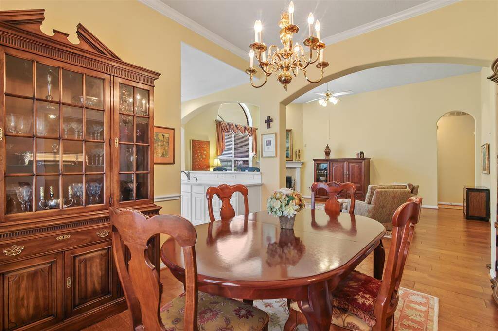 Dining room features crown molding and arched doorways connecting it to the kitchen and family room.