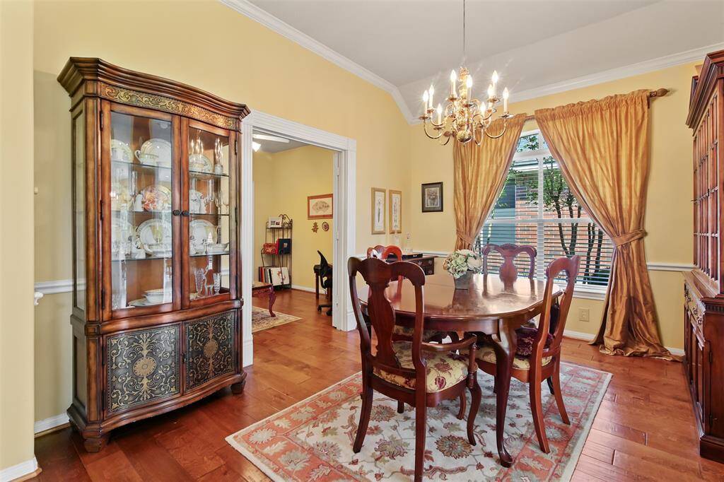 Another view of the dining room with wood  flooring and chair rail.