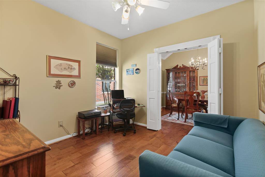 Study has wood floors, ceiling fan and sliding pocket doors connecting to the dining room.